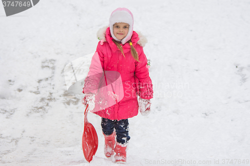 Image of The girl rolled down a hill climbs back on top