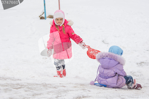 Image of Girl goes up the hill, the other girl rolls down