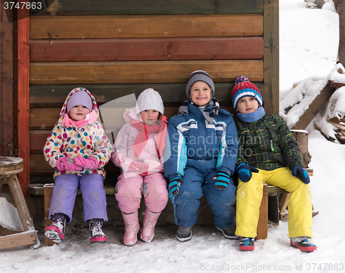 Image of little children group sitting  together  in front of wooden cabi