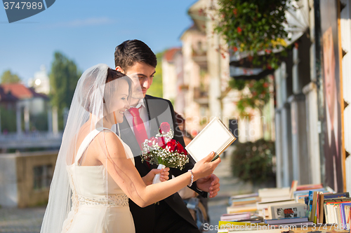 Image of Beautiful wedding couple reviewing vintage books.