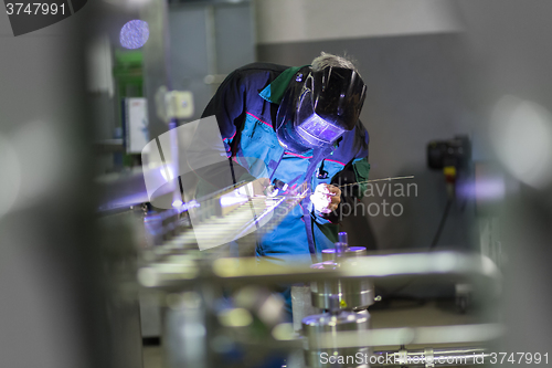 Image of Industrial worker welding in metal factory.