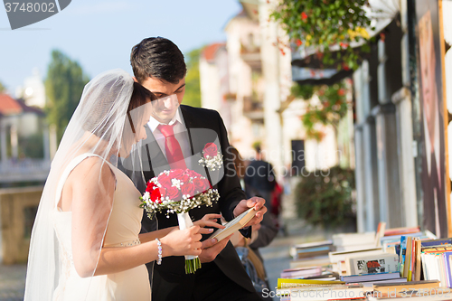 Image of Beautiful wedding couple reviewing vintage books.