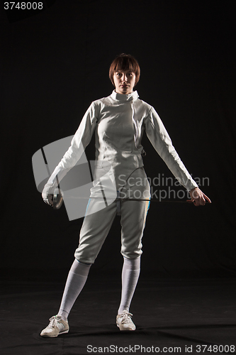 Image of The portrait of woman wearing white fencing costume  on black 