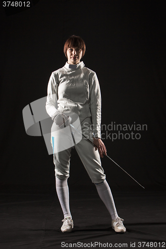 Image of The portrait of woman wearing white fencing costume  on black 