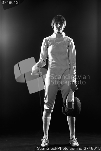 Image of The portrait of woman wearing white fencing costume  on black 