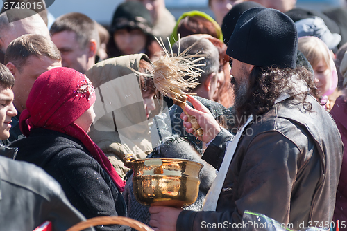 Image of Priest blessing people with holy water. Tyumen