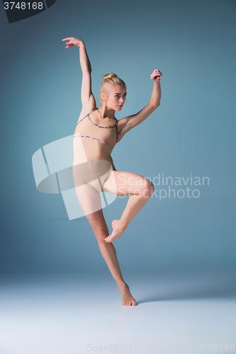 Image of Young beautiful modern style dancer jumping on a studio background