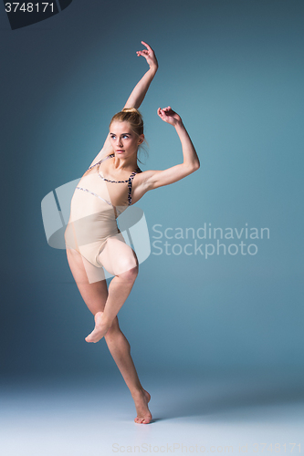 Image of Young beautiful modern style dancer jumping on a studio background