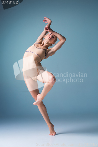 Image of Young beautiful modern style dancer jumping on a studio background