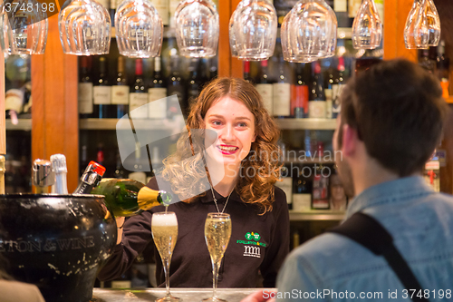 Image of Waitress serving champagne at San Miguel market, Madrid.