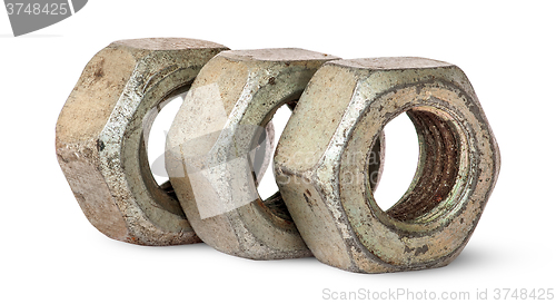 Image of Three old rusty nuts in a row rotated