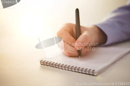 Image of The male hand with a pen 