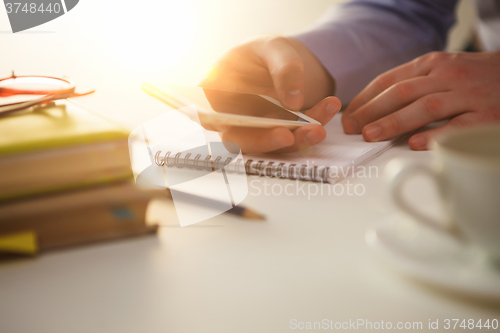 Image of The male hand holding a phone 