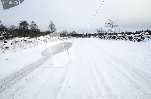 Image of Snowy road surrounded of stone walls