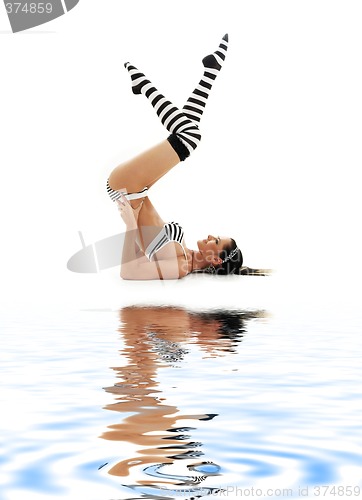 Image of striped underwear supported shoulderstand on white sand #2