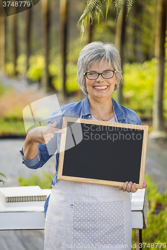 Image of Elderly woman in a green house