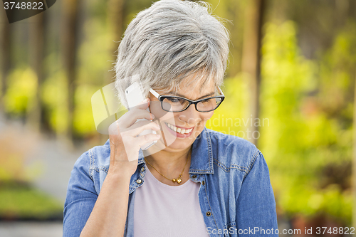 Image of Mature woman talking at phone