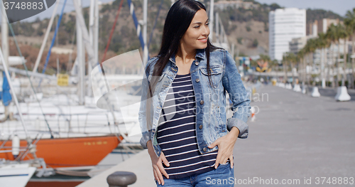 Image of Casual woman enjoying a walk through a marina