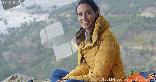 Image of Smiling young woman hiking in the mountains