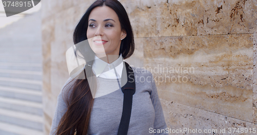 Image of Confident young woman leaning against wall