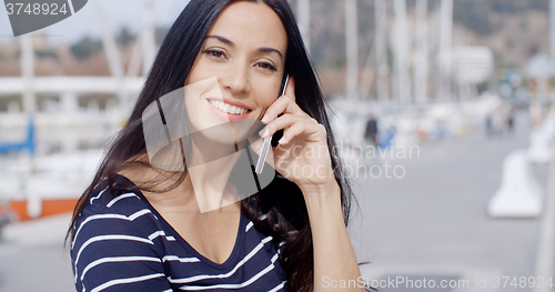 Image of Attractive smiling woman using a mobile phone