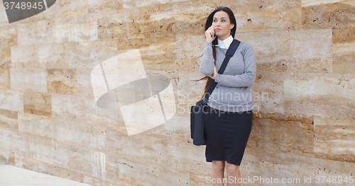 Image of Woman using phone and waiting on hold