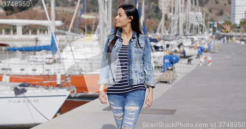 Image of Pretty woman strolling on a waterfront promenade