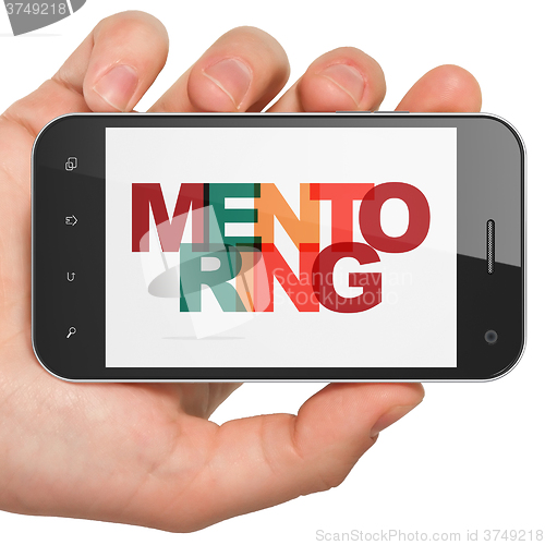 Image of Learning concept: Hand Holding Smartphone with Mentoring on  display