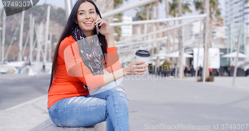 Image of Relaxed confident young woman on a mobile
