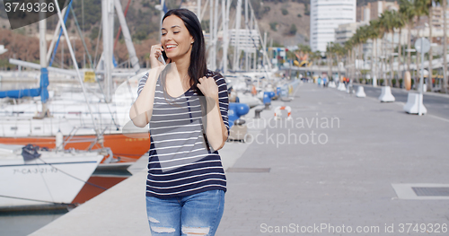 Image of Attractive woman walking past a marina