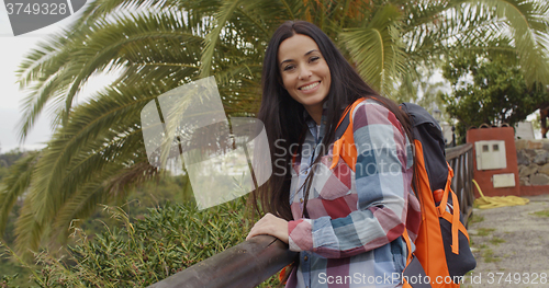 Image of Happy friendly woman wearing a backpack