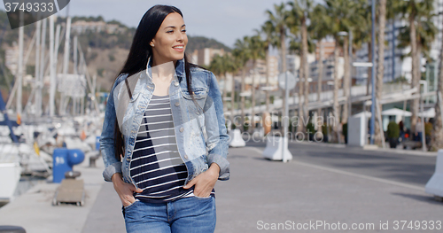 Image of Casual woman enjoying a walk through a marina