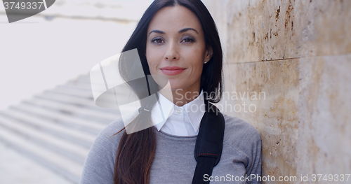 Image of Confident young woman leaning against wall