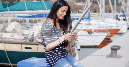 Image of Trendy young woman relaxing at a marine harbour