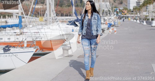 Image of Pretty woman strolling on a waterfront promenade