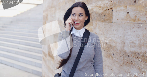 Image of Happy woman in sweater talking on phone