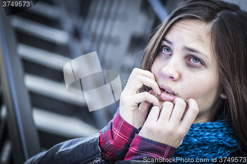 Image of Young Bruised and Frightened Girl on Staircase