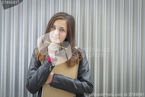 Image of Young Melancholy Female Student With Books Looking to the Side