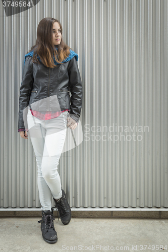 Image of Young Teen Girl Standing Against Metal Wall