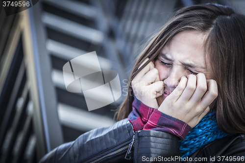 Image of Young Crying Teen Aged Girl on Staircase