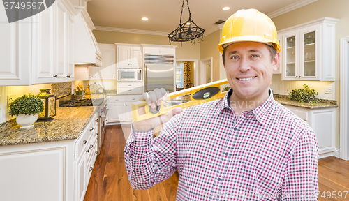 Image of Contractor with Level Wearing Hard Hat Standing In Custom Kitche