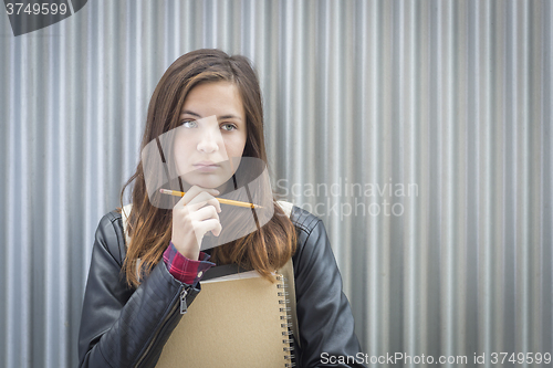 Image of Young Melancholy Female Student With Books Looking to the Side