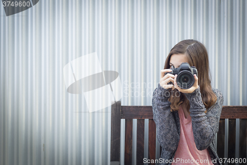 Image of Girl Photographer Sitting and Pointing Camera