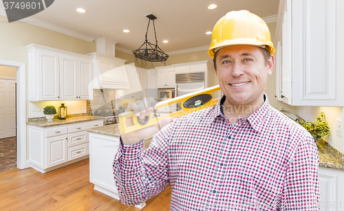 Image of Contractor with Level Wearing Hard Hat Standing In Custom Kitche