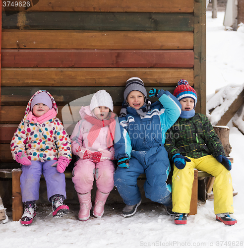 Image of little children group sitting  together  in front of wooden cabi