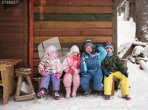 Image of little children group sitting  together  in front of wooden cabi