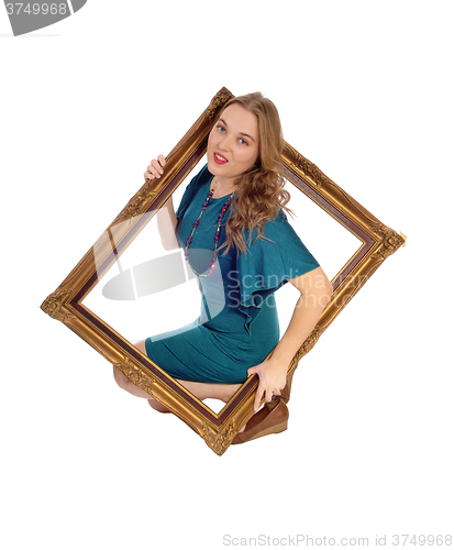 Image of Woman looking trough picture frame.