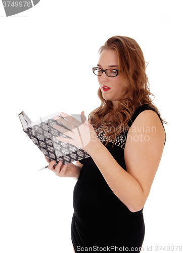 Image of Pretty woman reading in her journal.