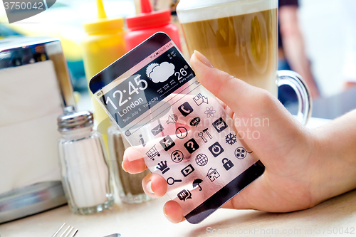 Image of Smartphone with transparent screen in human hands.