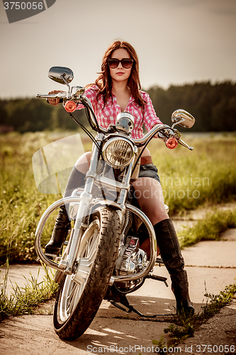 Image of Biker girl sitting on motorcycle